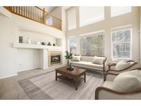 Living room with high ceilings, hardwood floors, and a fireplace at 11729 Elmer Linn Dr, Longmont, CO 80504