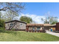 Charming home featuring a well-manicured lawn, mature trees and a welcoming front entrance with a pergola and flower boxes at 760 Deframe St, Golden, CO 80401