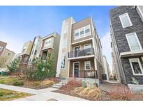 A modern three-story townhome with a balcony and a porch at 2415 Java Dr, Castle Rock, CO 80109