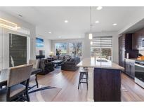 Bright, open-concept living room with hardwood floors and modern furnishings at 5110 E 64Th Ave, Commerce City, CO 80022