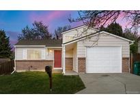 Charming home featuring a brick facade, a red front door, and an attached garage at 17753 E Nassau Pl, Aurora, CO 80013