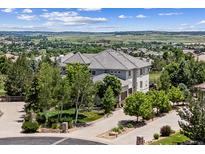 Beautiful two-story home boasts a tiled roof and gorgeous landscaping, set against a backdrop of rolling hills at 5665 Vistancia Ct, Parker, CO 80134