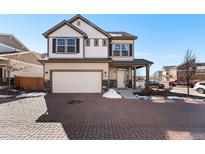 Charming two-story home with stone accents, a paved driveway, and a welcoming front porch at 10512 Truckee St, Commerce City, CO 80022