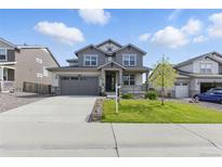 Charming two-story home features a landscaped front yard, inviting porch, and attached two-car garage in a suburban setting at 690 Avena Dr, Elizabeth, CO 80107