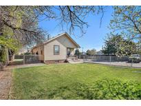 Charming bungalow with a well-manicured lawn and fenced yard provides space for outdoor enjoyment at 6411 E 64Th Ave, Commerce City, CO 80022