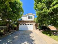 Charming two-story home with stone accents, well-manicured landscaping, and an attached two-car garage at 9466 Morning Glory Ln, Highlands Ranch, CO 80130