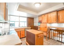 Charming kitchen featuring custom wood cabinets and a bright window over the sink at 10991 E Vassar Dr, Aurora, CO 80014