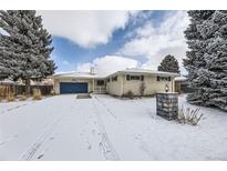 Charming single story home with a blue garage door, manicured lawn, and snow-covered front yard at 3630 S Hillcrest Dr, Denver, CO 80237