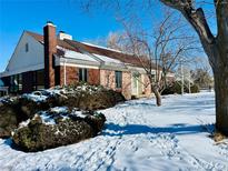 Charming single-story home with a manicured front yard covered in snow, showcasing its curb appeal and winter charm at 8897 Baseline Rd, Lafayette, CO 80026