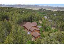 Stunning aerial view of mountain home surrounded by lush greenery and views of snow capped mountains in the background at 5 Ronnie Rd, Golden, CO 80403