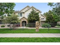 Charming home featuring a stone archway entrance, well-maintained landscaping, and black rod iron fencing at 10010 E Gunnison Pl # 707, Aurora, CO 80247
