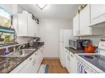 Galley kitchen features white cabinets, granite counters, and sleek stainless steel appliances at 2281 S Vaughn Way # 316A, Aurora, CO 80014