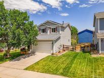 Charming two-story home with a well-manicured lawn and attached two-car garage at 9595 Elk Mountain Cir, Littleton, CO 80125