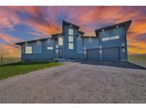 Stunning two-story home with modern design, three-car garage, unique roofline, and manicured lawn at 11680 Imboden Rd, Hudson, CO 80642