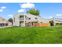 Spacious backyard showcasing a well-maintained lawn, a fenced in area, and a multi-level deck at 8738 Chase Dr # 134, Arvada, CO 80003
