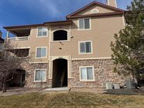 Attractive condo building showcasing stone accents and neutral siding, complete with well-maintained landscaping at 8520 S Holland Ln # 302, Littleton, CO 80128