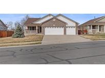 Charming two-story home featuring a brick facade, attached two-car garage, and a well-maintained front yard at 11237 W 55Th Ln, Arvada, CO 80002