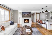 Inviting living room with hardwood floors, fireplace and bright, natural light from the large windows at 1908 Taft Dr, Lakewood, CO 80215