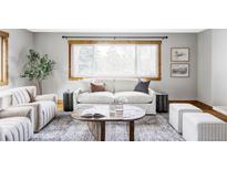 Bright living room features a large window, comfortable seating, stylish decor, and a cozy atmosphere at 1908 Taft Dr, Lakewood, CO 80215