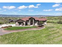 Charming home boasts a landscaped front yard, stone accents, and mountain views at 1701 Creedmoor Ct, Castle Rock, CO 80109