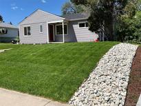 Charming home with a lush green lawn and decorative rock landscaping at 1405 S Utica St, Denver, CO 80219