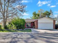 Charming one-story home with brick and siding, featuring a well-maintained front yard and attached two-car garage at 10878 Grange Creek Dr, Thornton, CO 80233