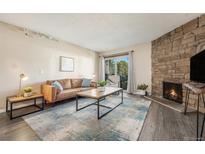 Inviting living room featuring a stone fireplace, plush sofa, and abundant natural light at 430 Zang St # 4-102, Lakewood, CO 80228