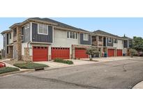 View of newly constructed townhomes featuring red garage doors and stone accents at 9300 E Florida Ave # 906, Denver, CO 80247