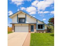 Charming home with a two-car garage, new siding, brick accents, lush lawn and beautiful landscaping at 8133 W Quarto Ave, Littleton, CO 80128
