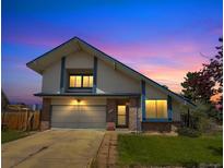 Charming two-story home with well-maintained lawn, brick accents, and an attached two-car garage during a scenic sunset at 8133 W Quarto Ave, Littleton, CO 80128