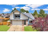 Charming two-story home with a brick accent, attached garage, and mature landscaping at 8133 W Quarto Ave, Littleton, CO 80128