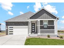 Beautiful home with a gray exterior, stone accents, a well-manicured lawn, and a two car garage at 42966 Colonial Trl, Elizabeth, CO 80107