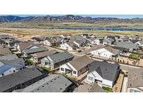 Stunning aerial view of a neighborhood near a lake, showcasing modern homes and scenic mountain views at 11492 Stonewash St, Littleton, CO 80125