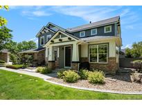 Charming two-story home with a covered porch, stone accents, and beautifully landscaped front yard at 2550 Winding River Dr # E1, Broomfield, CO 80023