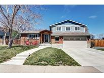 Charming two-story home with well-manicured lawn, brick accents, and attached two-car garage at 13915 W 73Rd Ave, Arvada, CO 80005