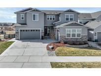 Beautiful gray two-story house with a well-manicured front yard and a two-car garage at 6977 Copper Sky Cir, Castle Pines, CO 80108
