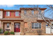 Charming two-story home with a red front door, stone facade, and well-maintained landscaping at 11307 Navajo Cir # A, Westminster, CO 80234