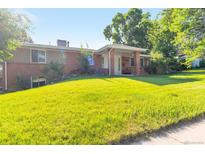 Charming single-Gathering home with lush green lawn and mature trees on a sunny day at 7930 S Kendall Ct, Littleton, CO 80128