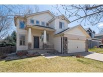 Charming two-story home with a welcoming front porch and a well-maintained lawn at 10806 Crooke Dr, Parker, CO 80134