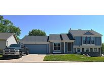 Charming two-story home with blue siding, stone accents, and a well-maintained front yard at 21518 E Powers Ln, Centennial, CO 80015