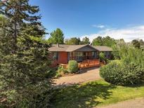 Charming brick home with a large wooden deck and mature trees at 5460 S Olive St, Greenwood Village, CO 80111