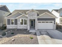 Charming single Gathering home featuring a stone facade, well-manicured lawn, and an attached two-car garage at 15776 Native Willow Dr, Monument, CO 80132
