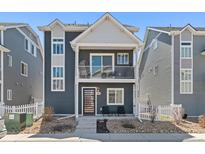 Charming two-story townhouse boasts a balcony, neutral siding, and well-manicured landscaping at 18644 E 54Th Pl, Denver, CO 80249