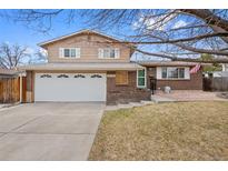 Charming two-story home with a well-manicured lawn, a two-car garage, and mature trees at 9415 Osceola St, Westminster, CO 80031