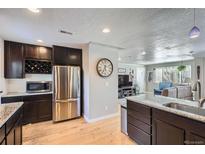 Modern kitchen features stainless steel appliances, granite countertops, and dark cabinetry at 2901 N Glencoe St, Denver, CO 80207