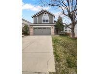 Two-story home featuring a gray exterior with a two-car garage and well-maintained front yard, offering curb appeal at 10707 Milliken St, Parker, CO 80134