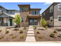 Charming two-story home with a stone facade and manicured front yard at 21044 E 63Rd Dr, Aurora, CO 80019