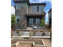 Charming two-story home featuring stone accents, a well-kept front yard, and a welcoming covered entry at 21044 E 63Rd Dr, Aurora, CO 80019
