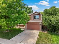 Charming two-story home with a well-maintained lawn and mature trees providing shade at 4393 E Andover Ave, Castle Rock, CO 80104