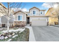 Charming home with a two-car garage, stone accents, and landscaped front yard at 2594 Scoter Ln, Castle Rock, CO 80104
